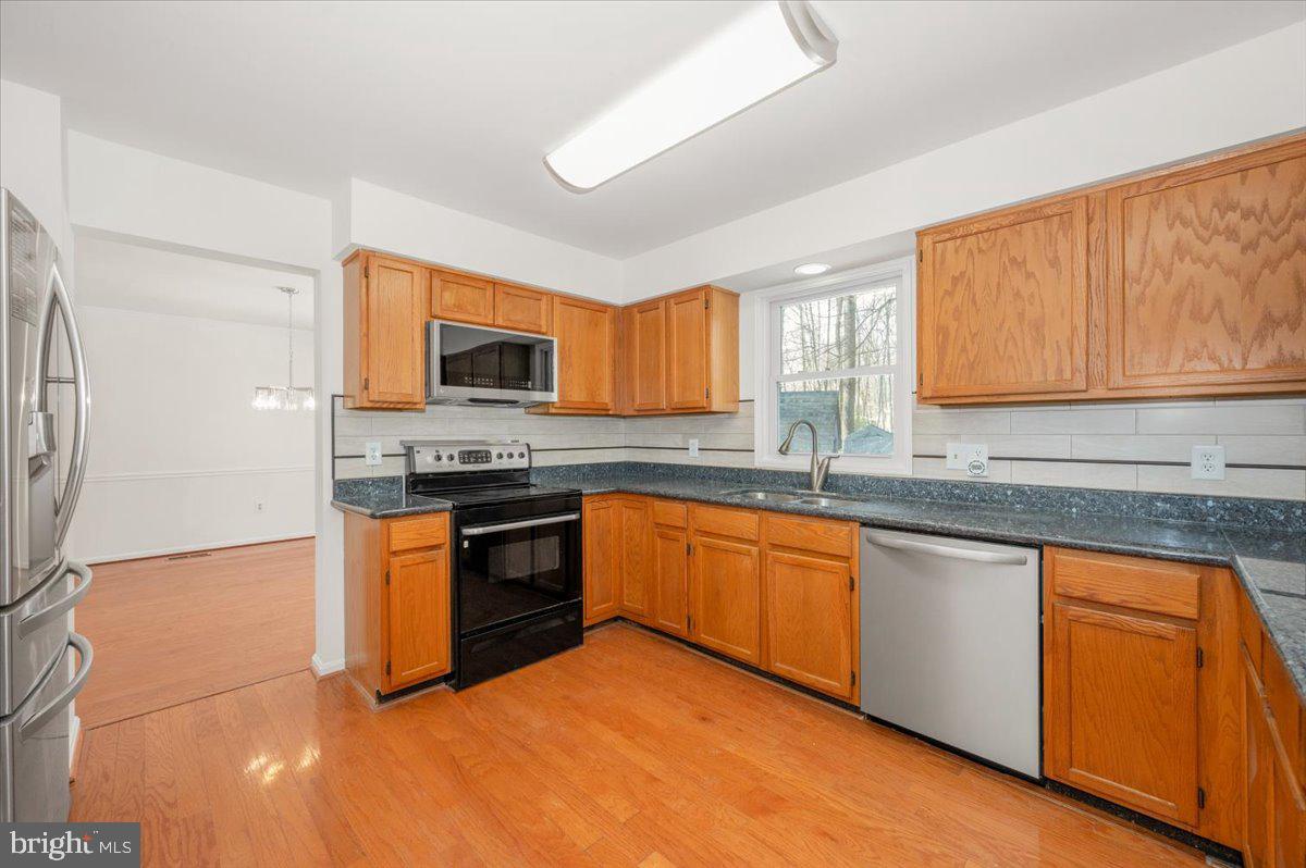 1404 Partridge Lane Bowie, MD 20721 - Photo 20 of 78 a kitchen with stainless steel appliances granite countertop a stove a sink and a microwave