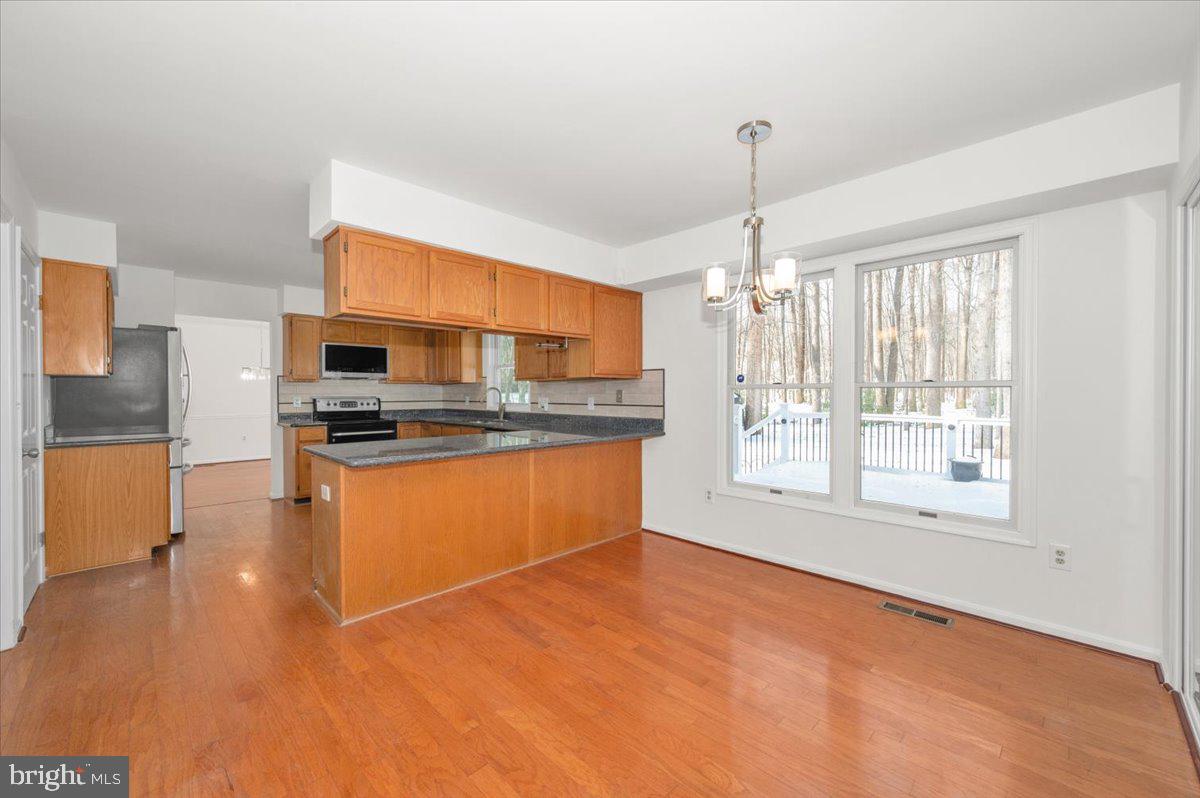 1404 Partridge Lane Bowie, MD 20721 - Photo 23 of 78 a kitchen with stainless steel appliances granite countertop a stove a sink and a refrigerator