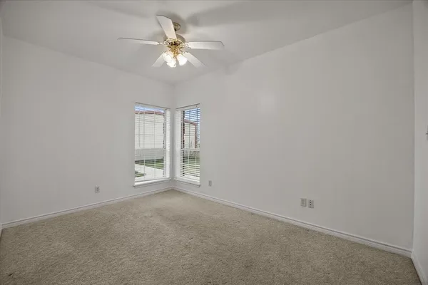 an empty room with chandelier fan