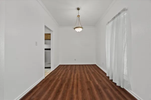 a view of a room with wooden floor and entryway