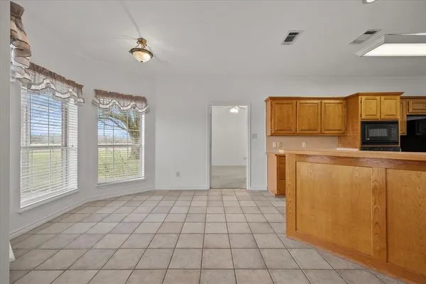 a view of a kitchen with microwave and refrigerator