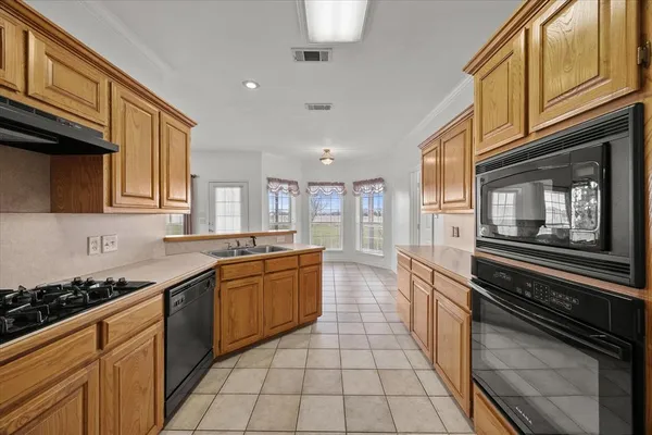 a large kitchen with stainless steel appliances granite countertop a stove and cabinets
