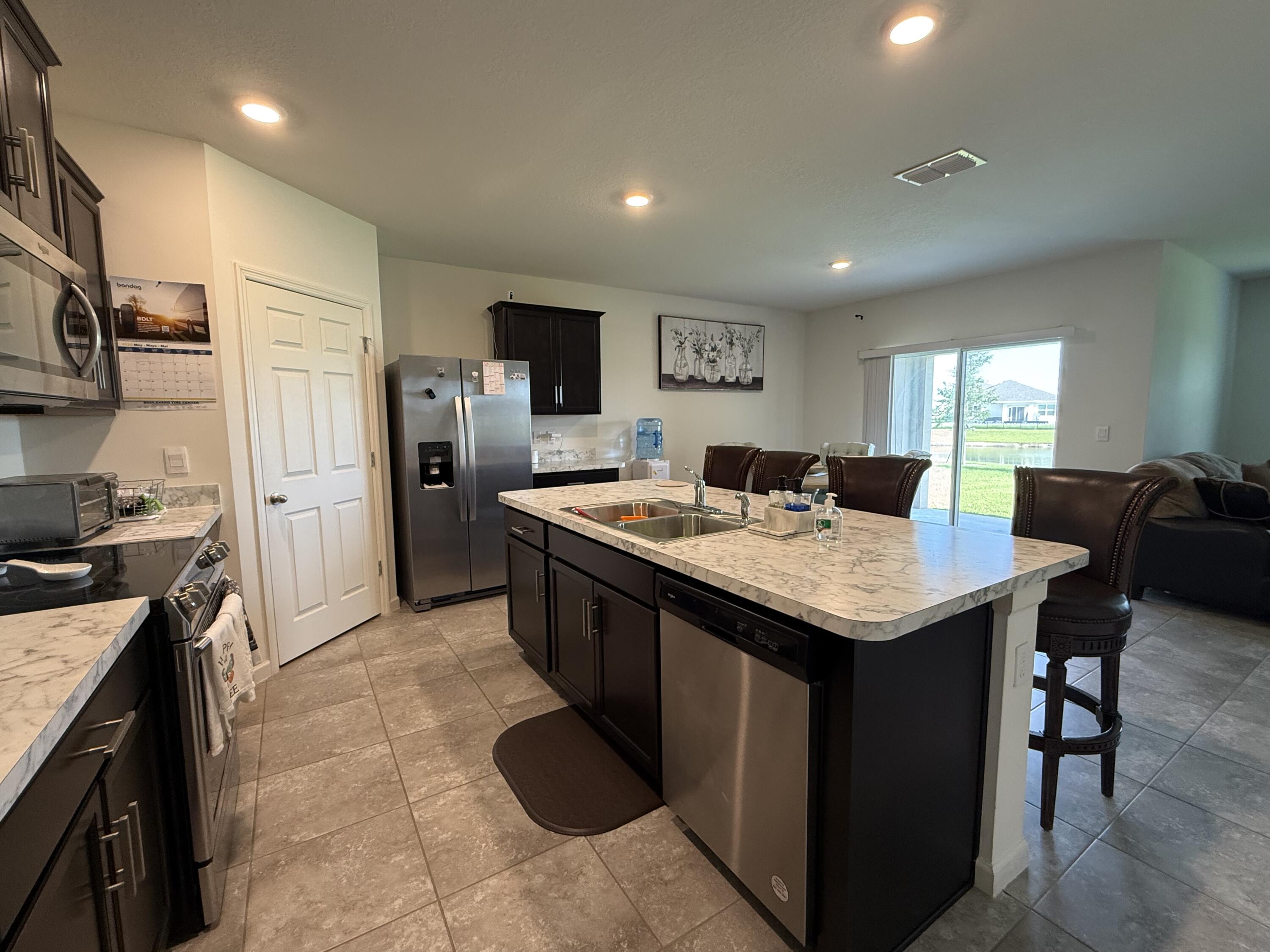 9511 Potomac Drive Fort Pierce, FL 34945 - Photo 12 of 26 a kitchen with stainless steel appliances granite countertop a sink a stove and refrigerator