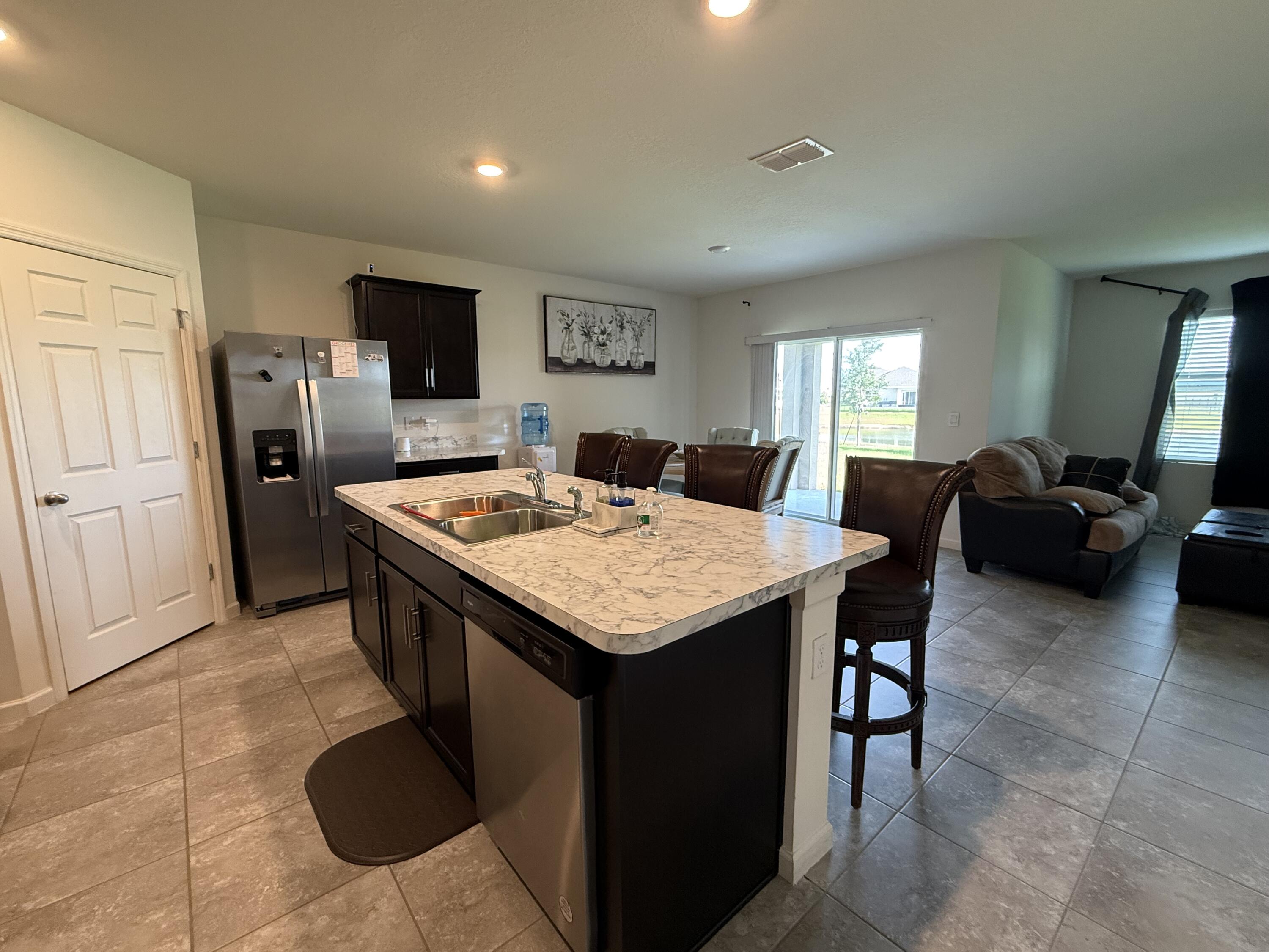 9511 Potomac Drive Fort Pierce, FL 34945 - Photo 13 of 26 a large kitchen with a table chairs and refrigerator