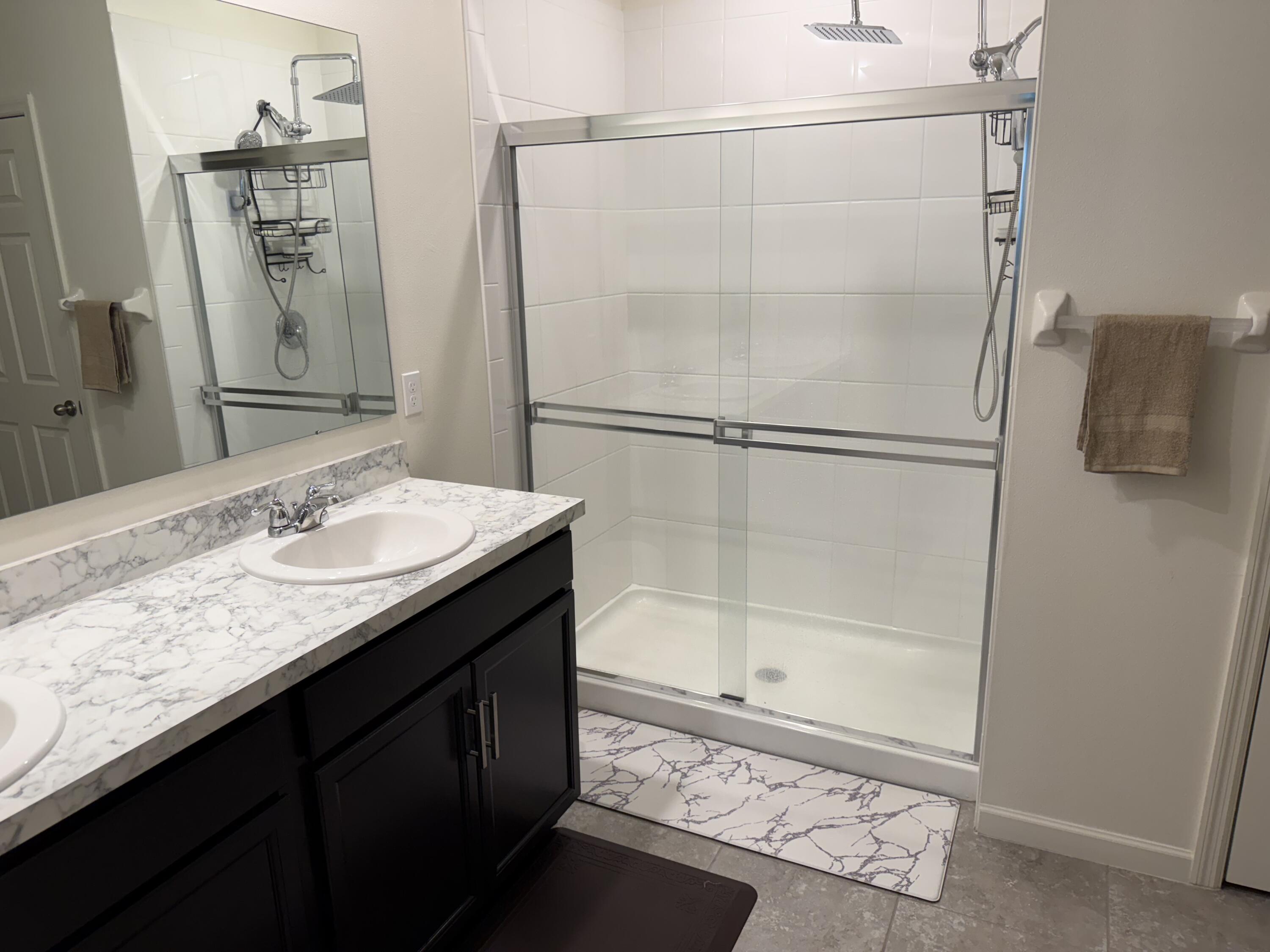 9511 Potomac Drive Fort Pierce, FL 34945 - Photo 17 of 26 a bathroom with a granite countertop sink a mirror and a shower