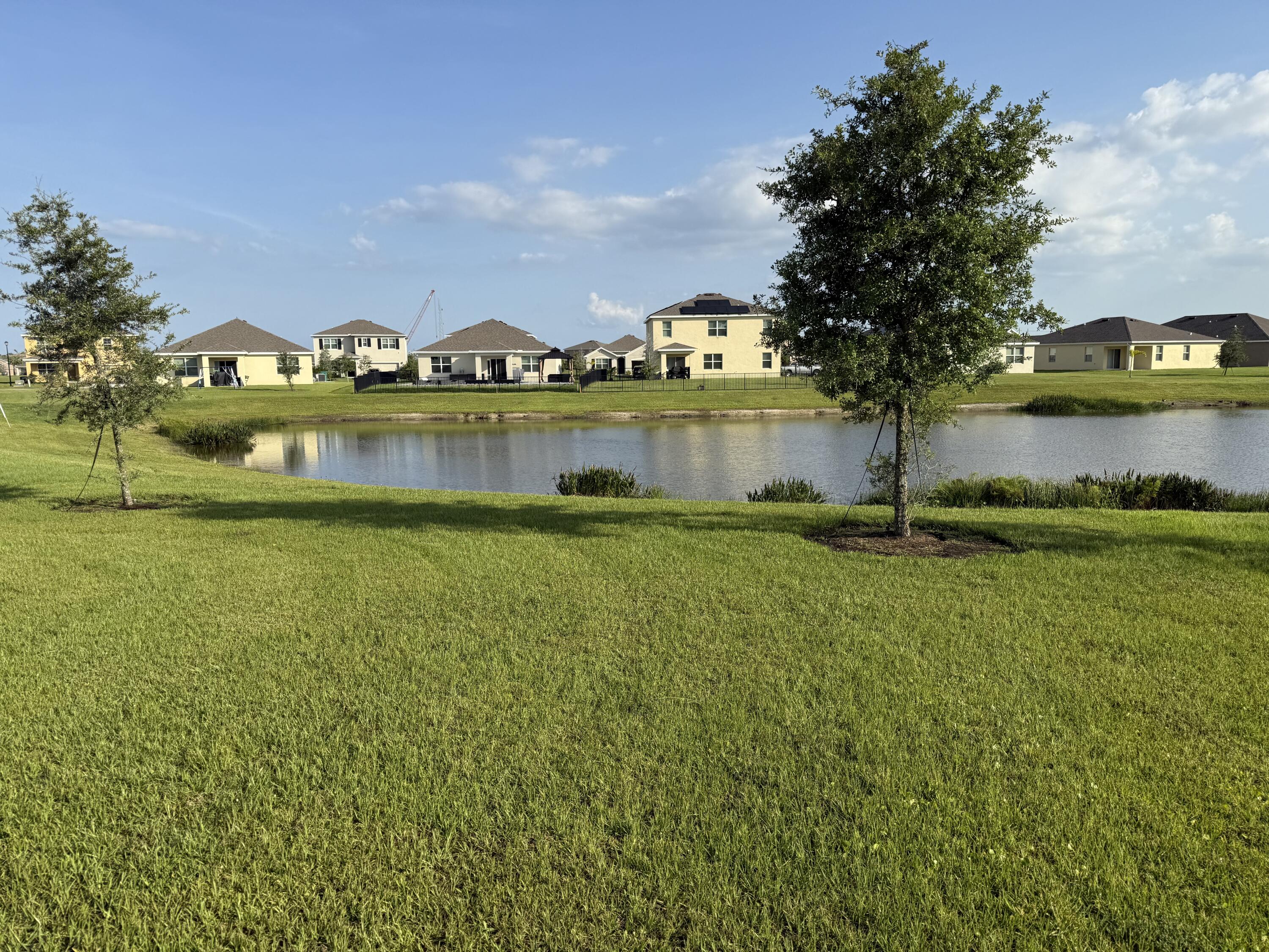 9511 Potomac Drive Fort Pierce, FL 34945 - Photo 23 of 26 a view of a lake with houses in the back