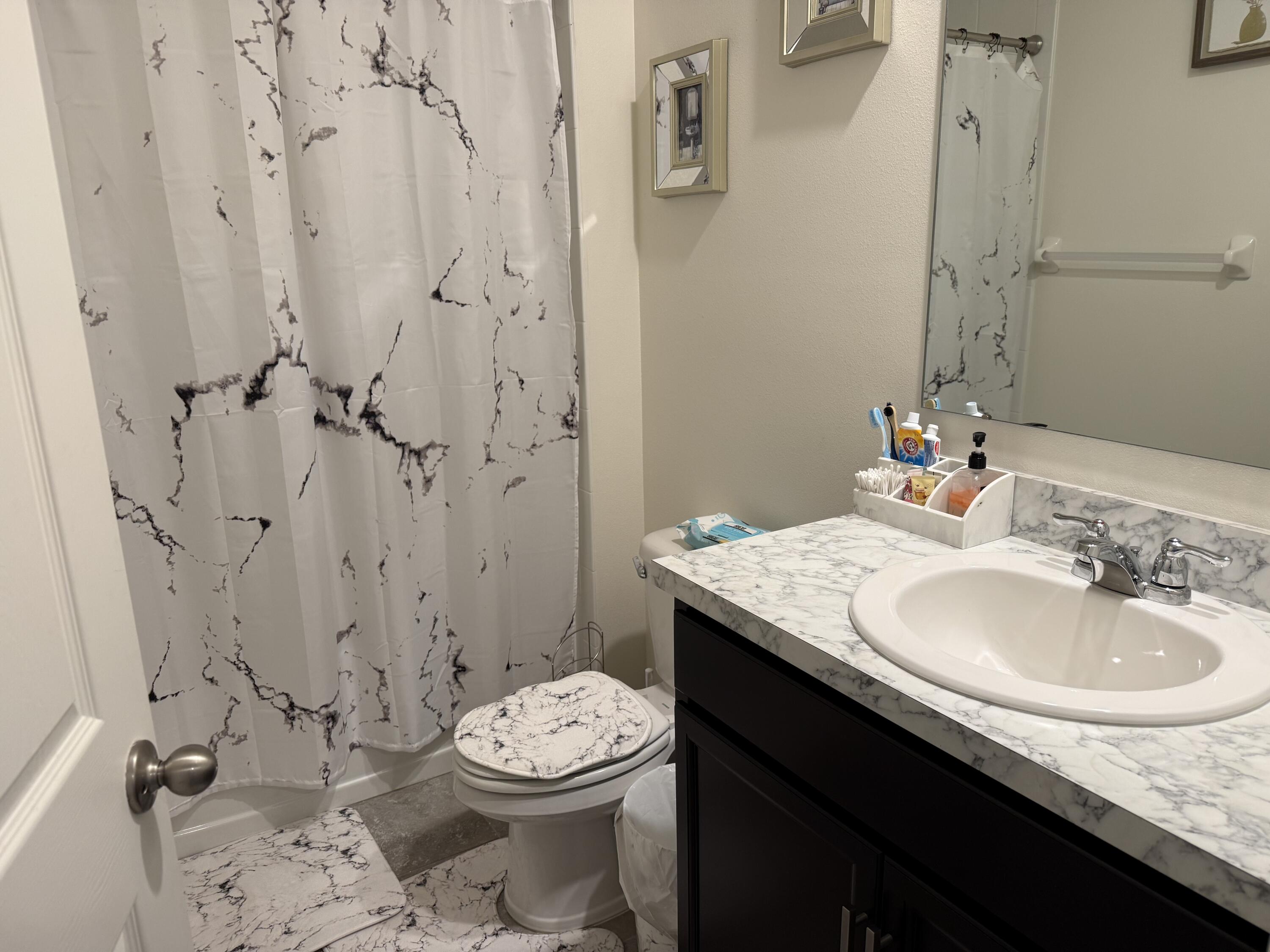 9511 Potomac Drive Fort Pierce, FL 34945 - Photo 3 of 26 a bathroom with a granite countertop sink toilet and a mirror