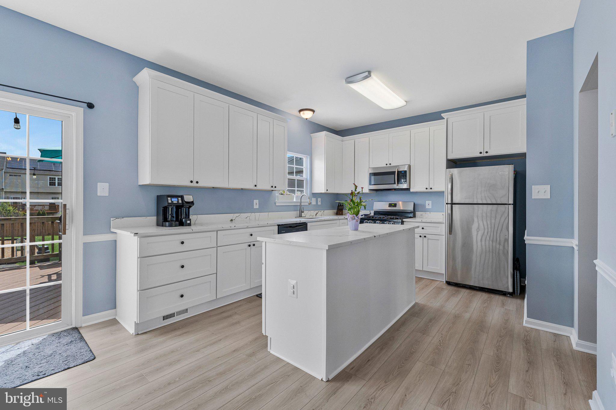 590 Tuliptree Square Northeast Leesburg, VA 20176 - Photo 15 of 54 a kitchen with white cabinets and stainless steel appliances
