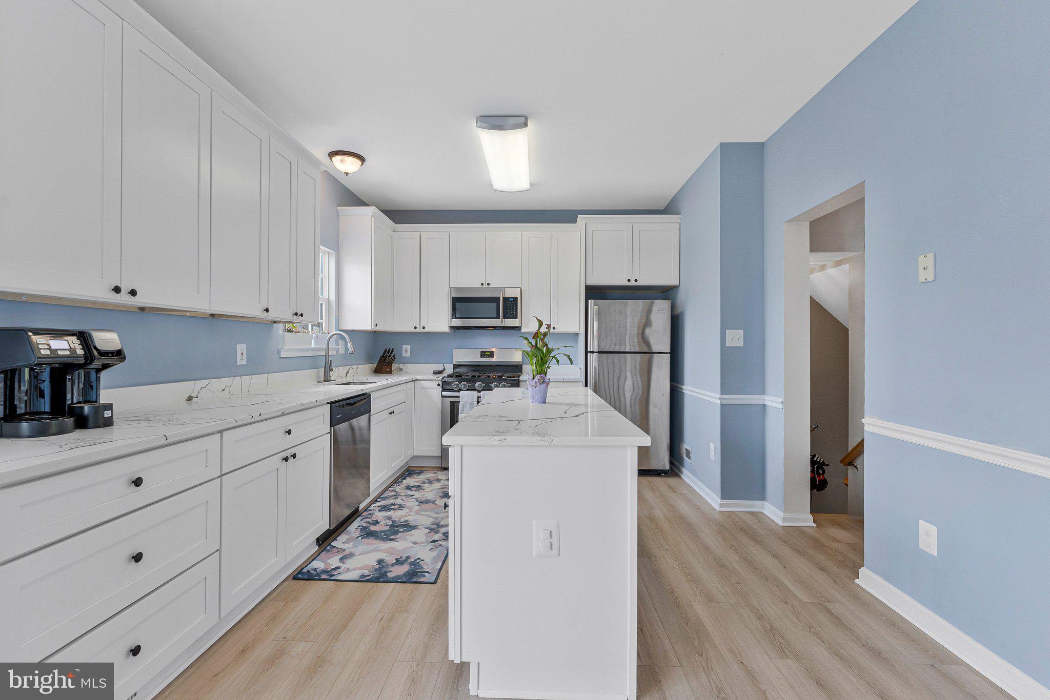590 Tuliptree Square Northeast Leesburg, VA 20176 - Photo 16 of 54 a kitchen with white cabinets and stainless steel appliances