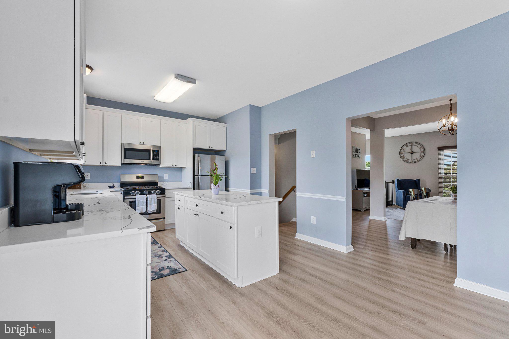 590 Tuliptree Square Northeast Leesburg, VA 20176 - Photo 17 of 54 a kitchen with stainless steel appliances a refrigerator sink and cabinets