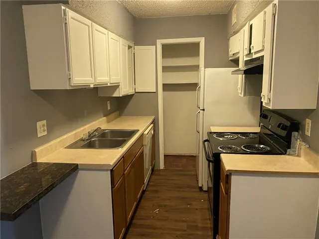 a kitchen with a sink stove and cabinets
