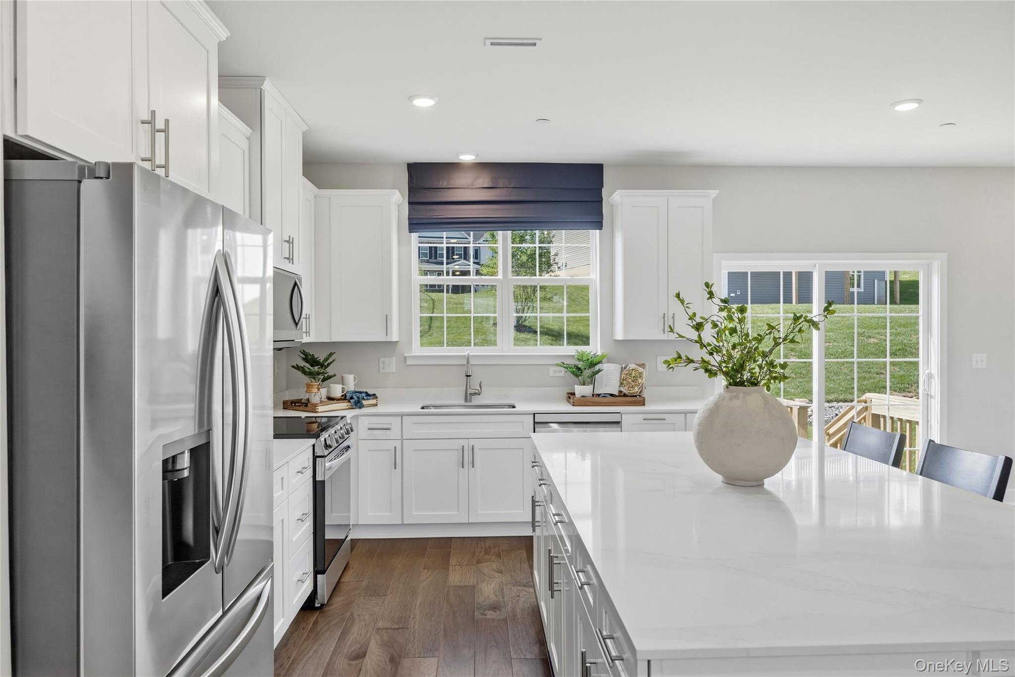 154 Pine Ridge Road Tuxedo Park, NY 10987 - Photo 7 of 25 a kitchen with stainless steel appliances granite countertop a refrigerator a sink dishwasher a stove and white cabinets with wooden floor