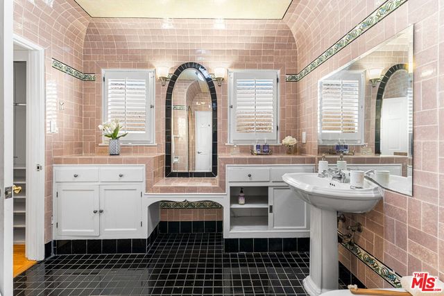 a bathroom with a sink a mirror and a window