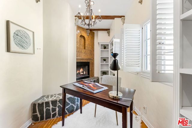 a view of a workspace with furniture and a window