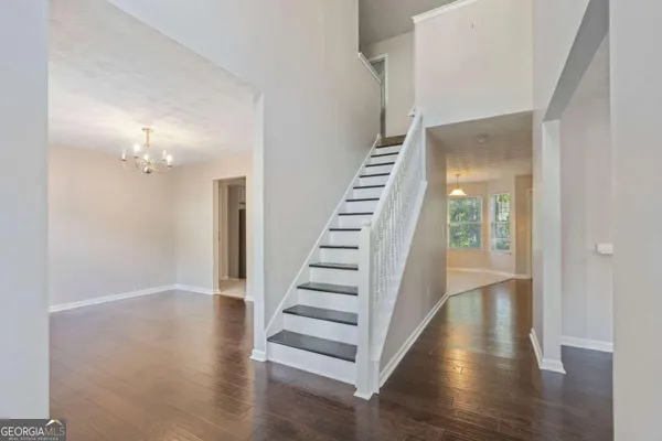 a view of a hallway with wooden floor and entryway