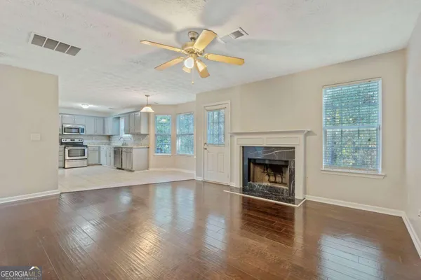 a view of an empty room with wooden floor and a window