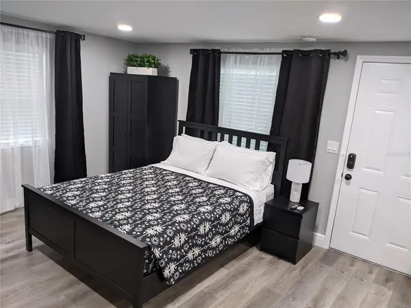 a black leather couch sitting in a bedroom next to a window