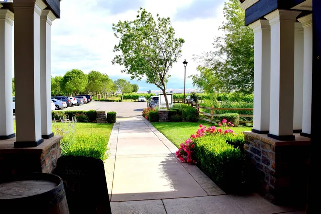a view of a table with chairs in front of yellow house