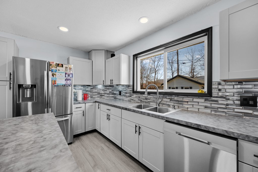 8012 10th Street West Rock Island, IL 61201 - Photo 16 of 27 a kitchen with stainless steel appliances granite countertop a sink stove and refrigerator