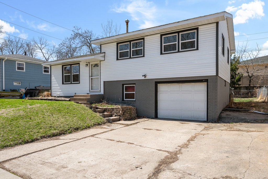 8012 10th Street West Rock Island, IL 61201 - Photo 3 of 27 a front view of a house with a yard and garage