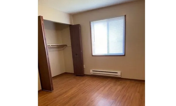 a view of a room with wooden floor and a window