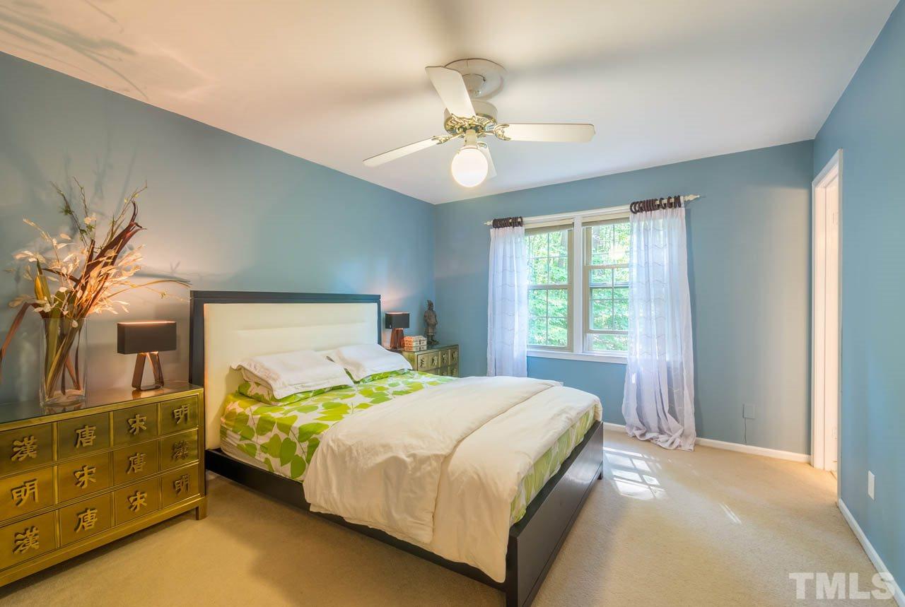 1700 Tropical Drive Raleigh, NC 27607 - Photo 9 of 25 a bedroom with a bed and a chandelier