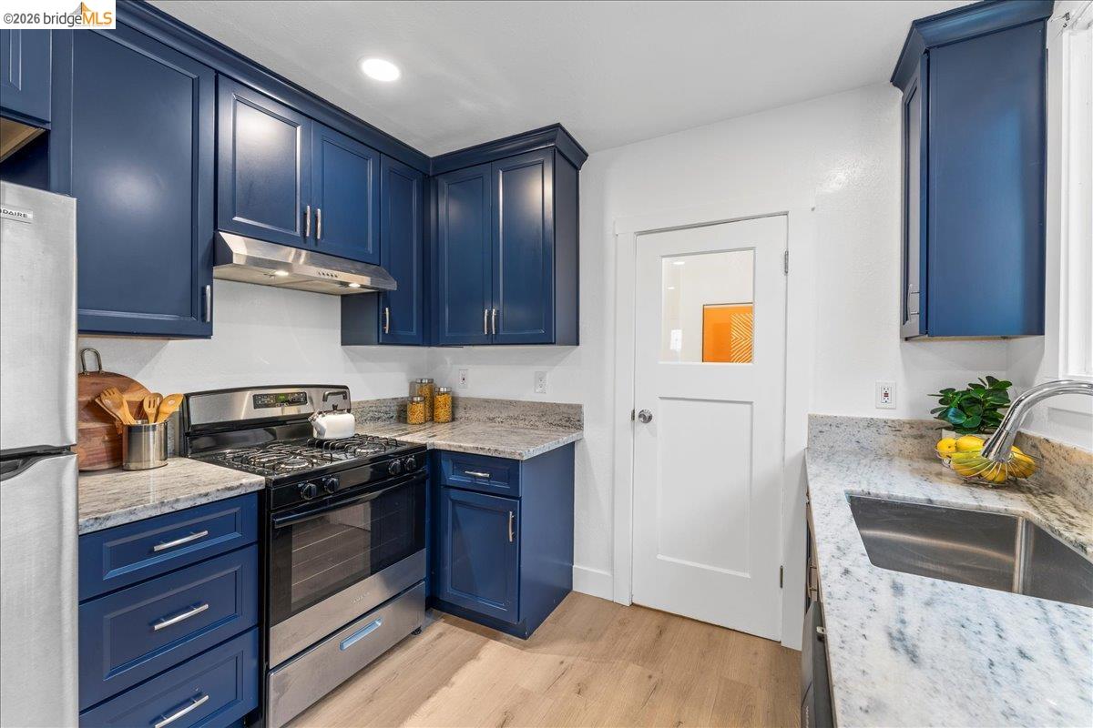 2717 Mabel Street Berkeley, CA 94702 - Photo 29 of 60 a kitchen with granite countertop wooden cabinets and white appliances