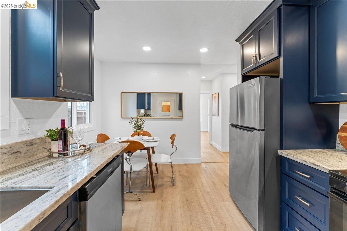 2717 Mabel Street Berkeley, CA 94702 - Photo 3 of 60 a kitchen with stainless steel appliances granite countertop a refrigerator a sink dishwasher a stove and a dining table with wooden floor