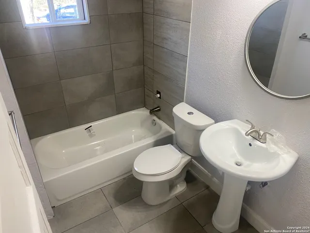 a white toilet sitting next to a bathroom sink