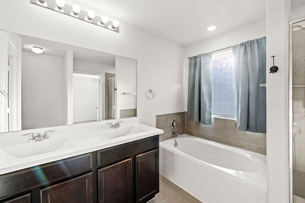 3621 Colorado High Avenue Austin, TX 78744 - Photo 24 of 40 a bathroom with a tub a sink and a mirror