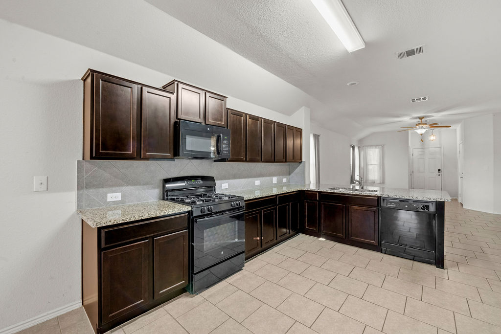 3621 Colorado High Avenue Austin, TX 78744 - Photo 9 of 40 a kitchen with stainless steel appliances granite countertop a stove sink and cabinets