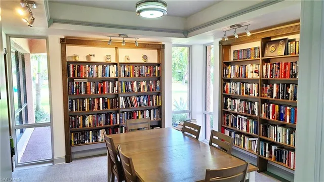 a view of a workspace with furniture and a bookshelf