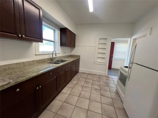 a kitchen with a sink a refrigerator and cabinets