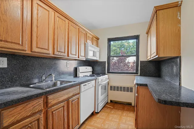 a kitchen with stainless steel appliances granite countertop a sink a stove and cabinets