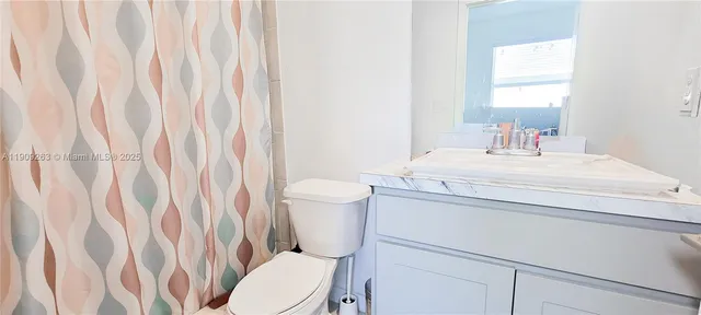a bathroom with a sink a toilet and shower curtain
