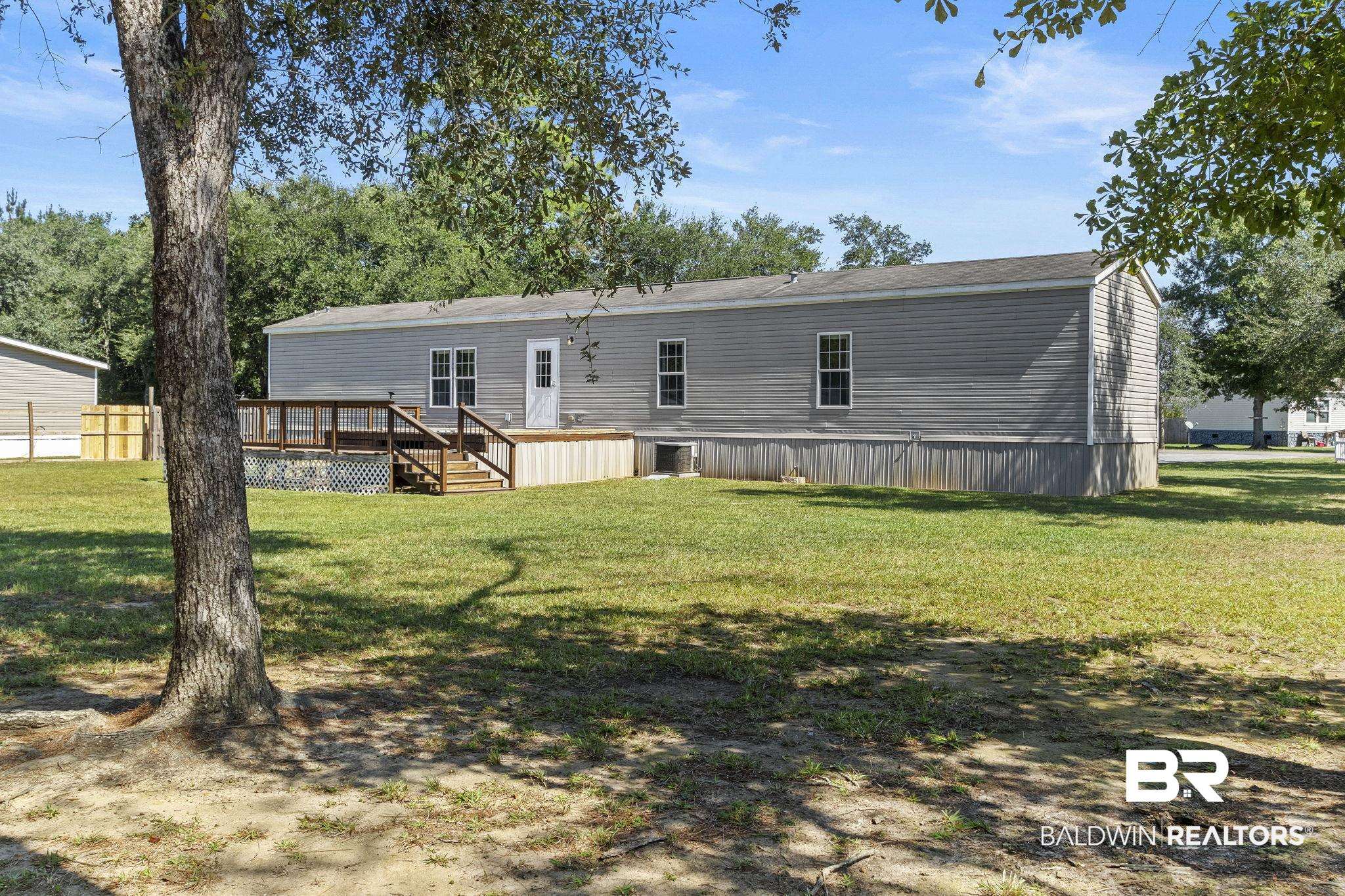 6870 Cecilia Court Theodore, AL 36582 - Photo 52 of 83 Rear view of house with a lawn and a wooden deck