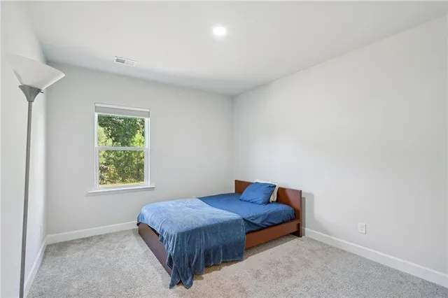 a spacious bedroom with a bed and a window