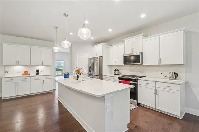 a large white kitchen with stainless steel appliances