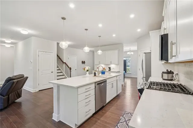 a large kitchen with stainless steel appliances kitchen island a large counter top a sink a stove and a refrigerator