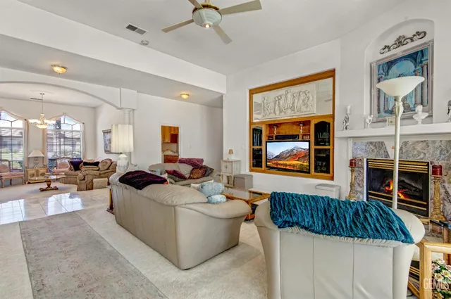 a living room with furniture a fireplace and a flat screen tv