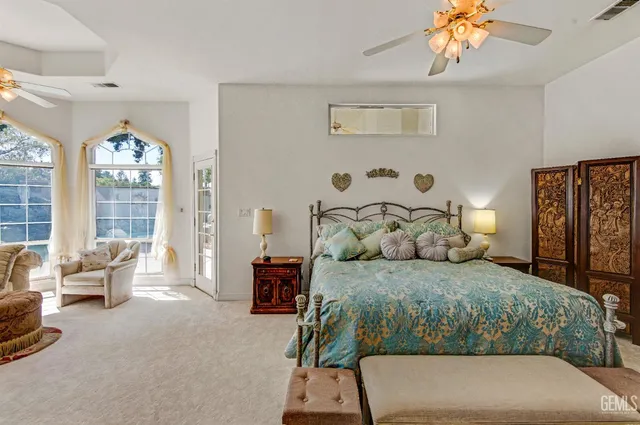 a bedroom with a large bed and windows