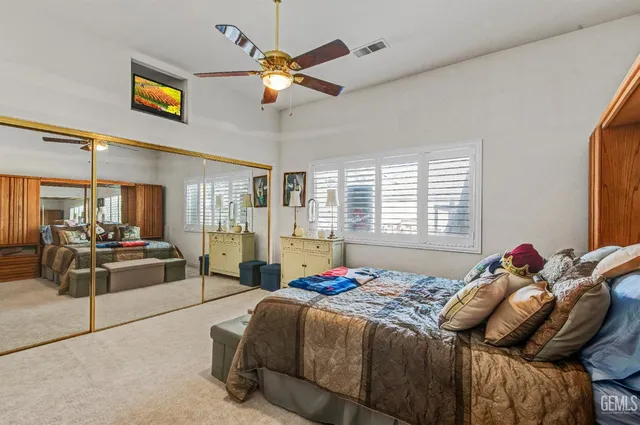 a spacious bedroom with a bed and a chandelier