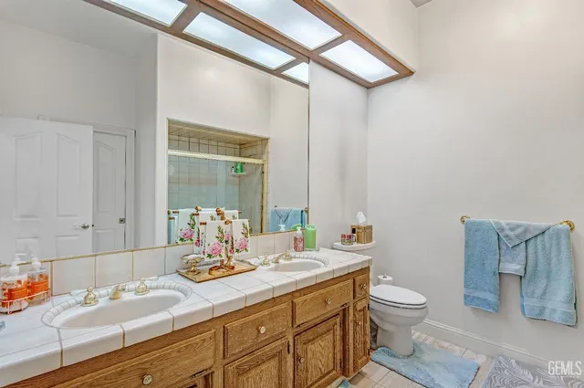a bathroom with a granite countertop sink mirror vanity and toilet