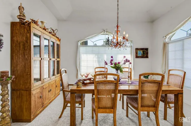 a dining room with furniture a chandelier and window