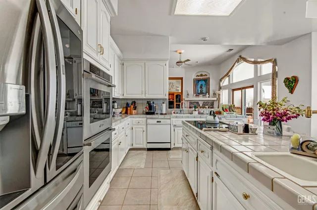 a view of a kitchen with fridge and workspace