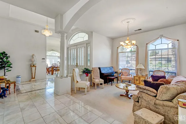 a living room with furniture and a chandelier