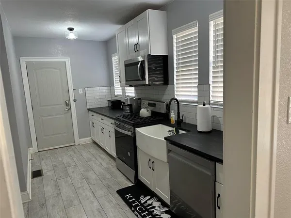 a kitchen with a sink stove and microwave