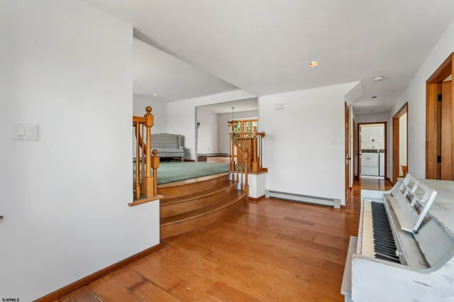 a view of a livingroom with wooden floor and furniture