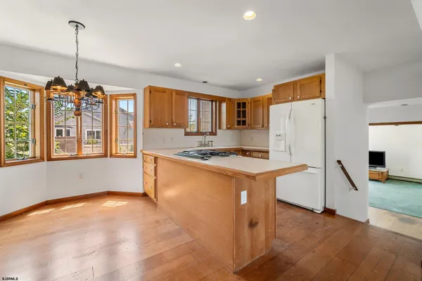 a kitchen that has a refrigerator a stove a sink and a wooden floor