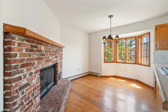 a view of an empty room with a fireplace and a window